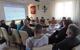 Widok sali konferencyjnej z zebranymi uczestnikami spotkania informacyjnego dotyczącego dotacji.