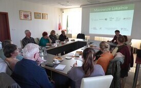 Widok sali konferencyjnej z zebranymi uczestnikami spotkania informacyjnego dotyczącego dotacji.