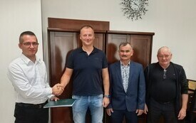 Zdjęcie przedstawicieli samorzadu z wykonawcą inwestycji. Burmistrz oraz wykonawca uscisnęli sobie dłoń.