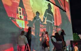 Powstający mural na ścianie budynku w Chorzelach. Widoczne są pierwsze elementy projektu przygotowanego przez młodzież.