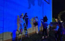 Powstający mural na ścianie budynku w Chorzelach. Widoczne są pierwsze elementy projektu przygotowanego przez młodzież.