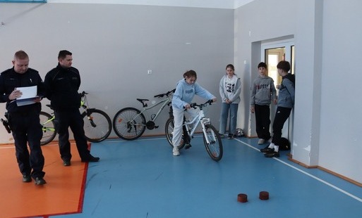 Zdjęcie przedstawia policjantów oraz chłopca na rowerze