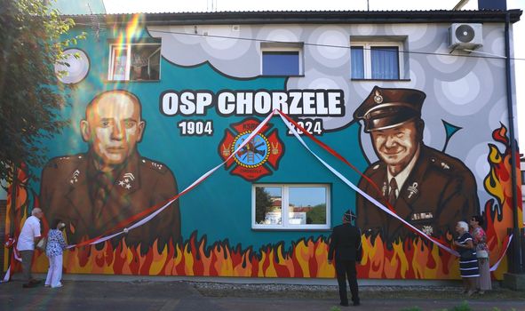 3 kobiety i mężczyzna odsłaniają mural upamiętniający 120-lecie OSP Chorzele