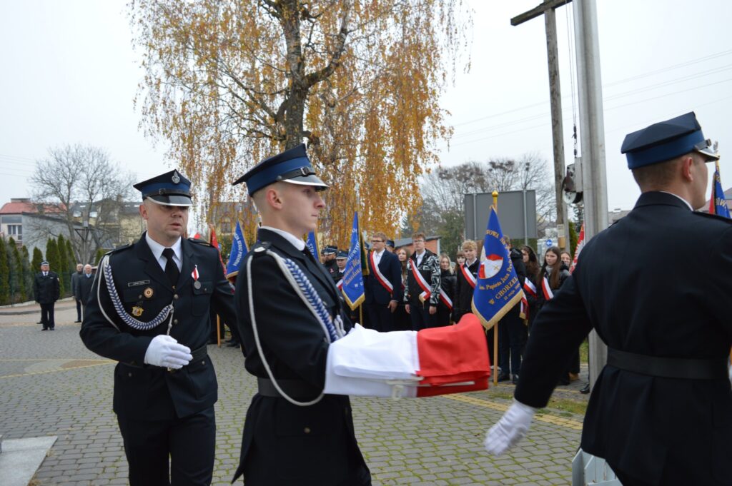 Delegacja niesie flagę Polski do zawieszenia na maszt.