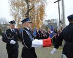 Delegacja niesie flagę Polski do zawieszenia na maszt.