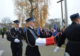 Delegacja niesie flagę Polski do zawieszenia na maszt.